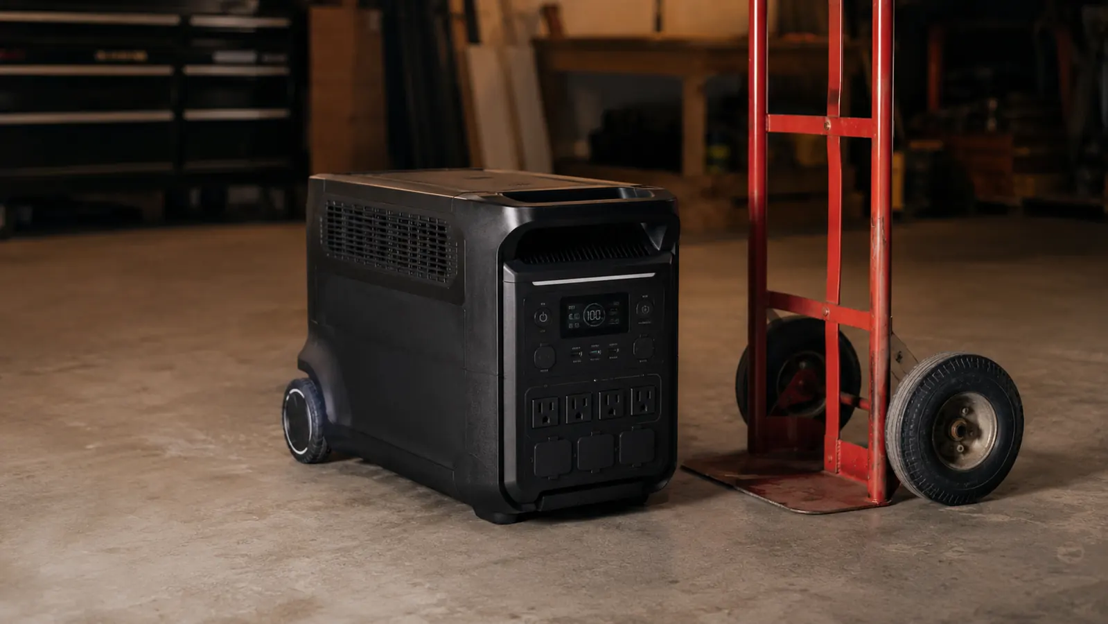 EcoFlow Delta Pro power station sitting on a garage floor next to a hand truck, conveying the size and weight of the unit