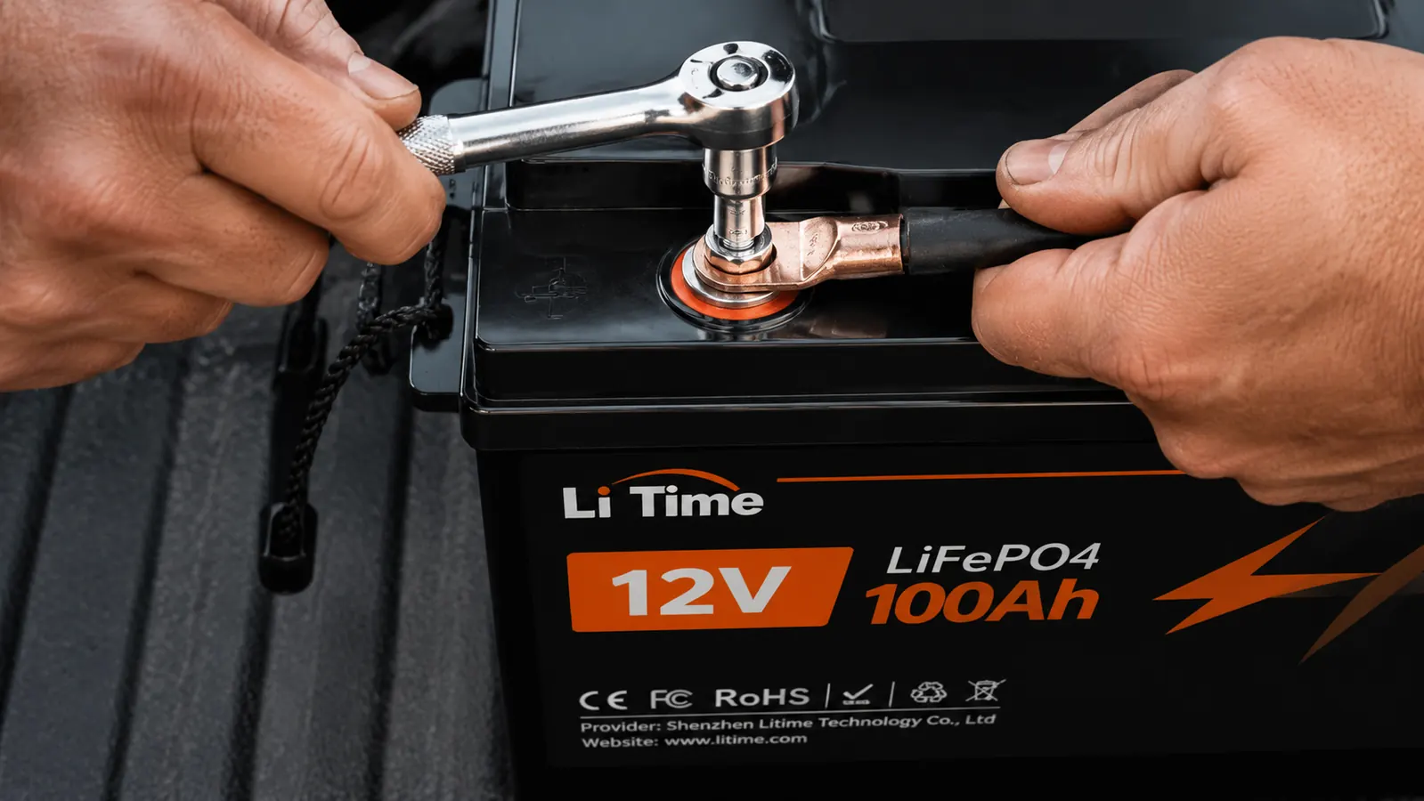 Close-up of LiTime battery terminals showing M8 bolt holes with an attached ring terminal lug