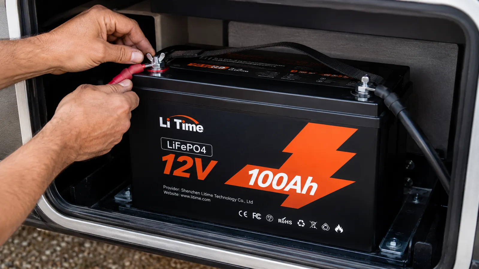 LiTime 12V 100Ah LiFePO4 battery installed in RV battery compartment with wiring visible